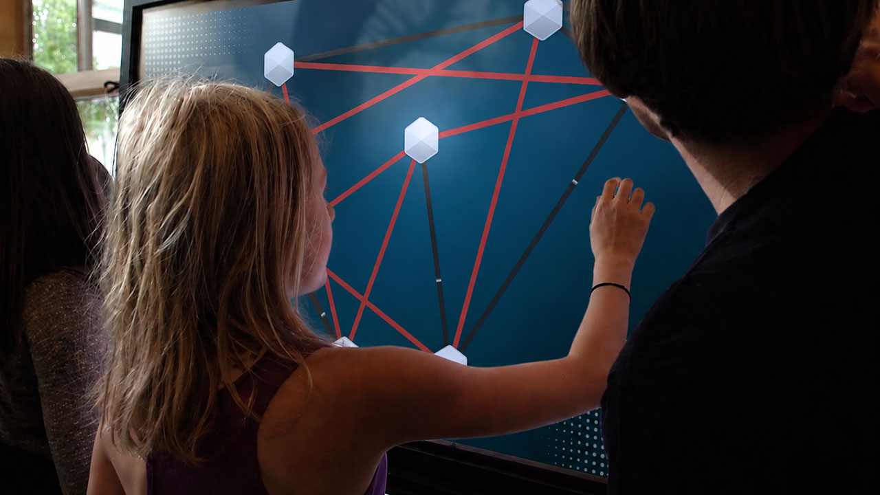 Children interacting with collaborative multi-touch applications using NUITEQ Campfire interactive game software for touchscreens.